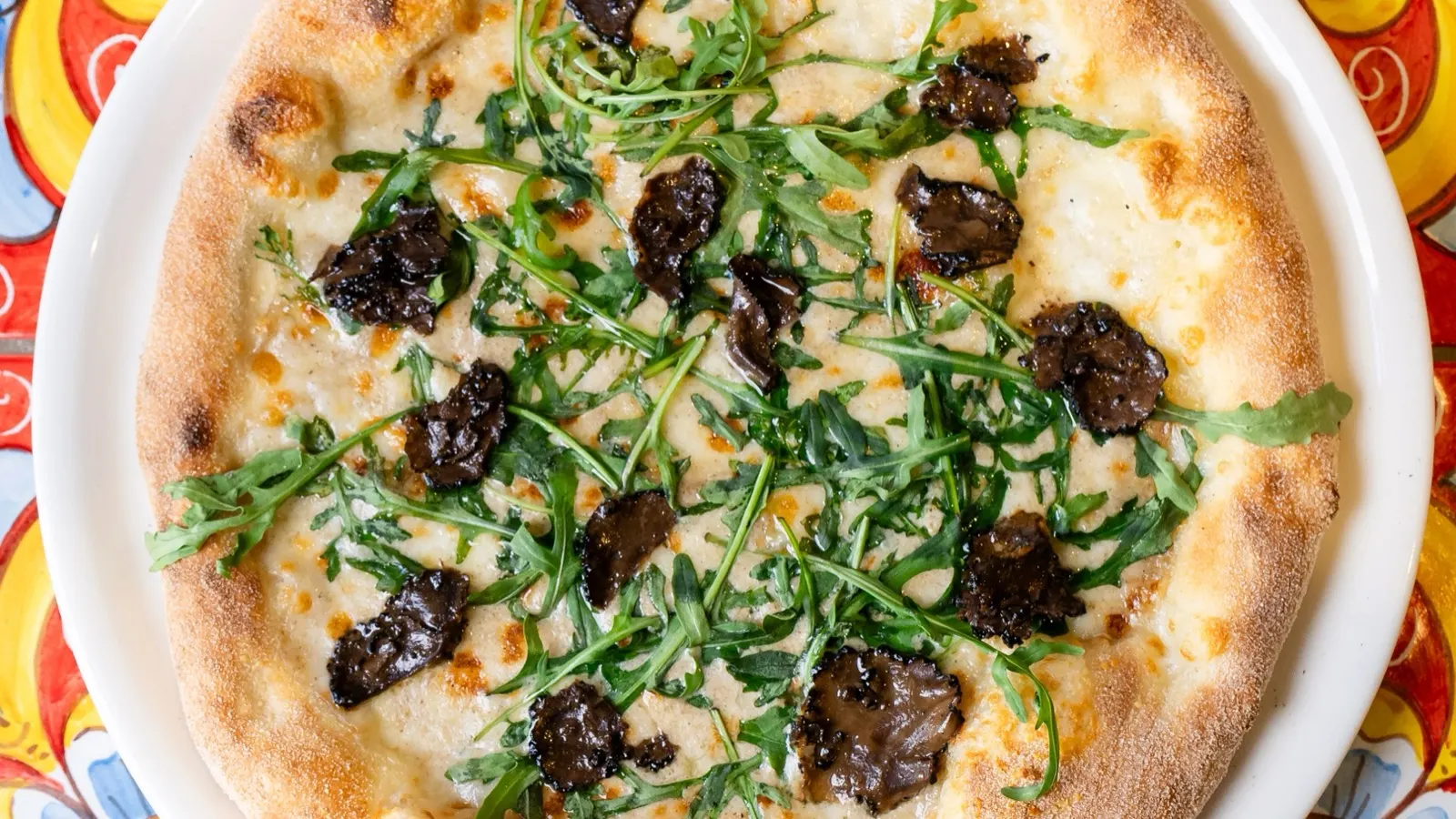 Pizza au feu de bois sortie du four chez Casa Capri