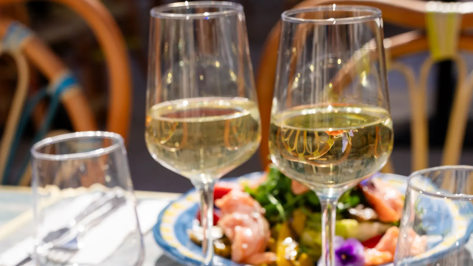 Deux verres de vin blanc sur une table en terrasse chez Casa Capri