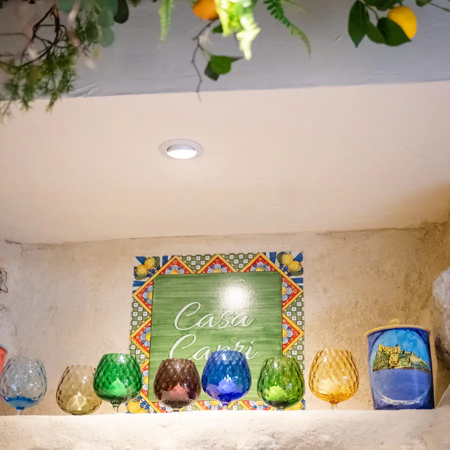 L'enseigne Casa Capri peinte sur carreau, entourée de verres colorés soufflés à la main.