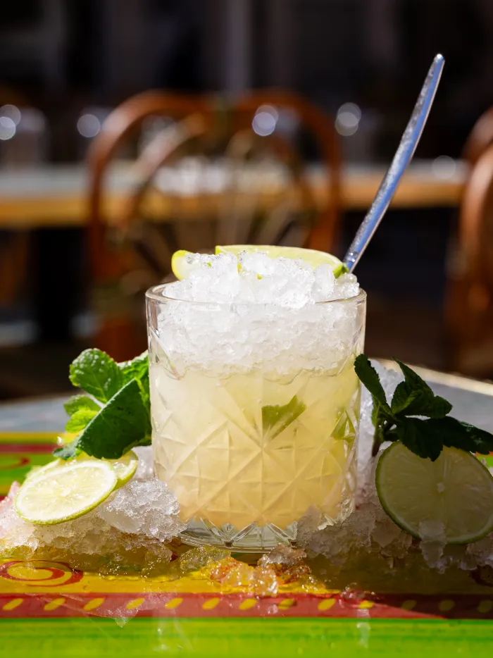 Un cocktail préparé devant les bouteilles du bar Casa Capri